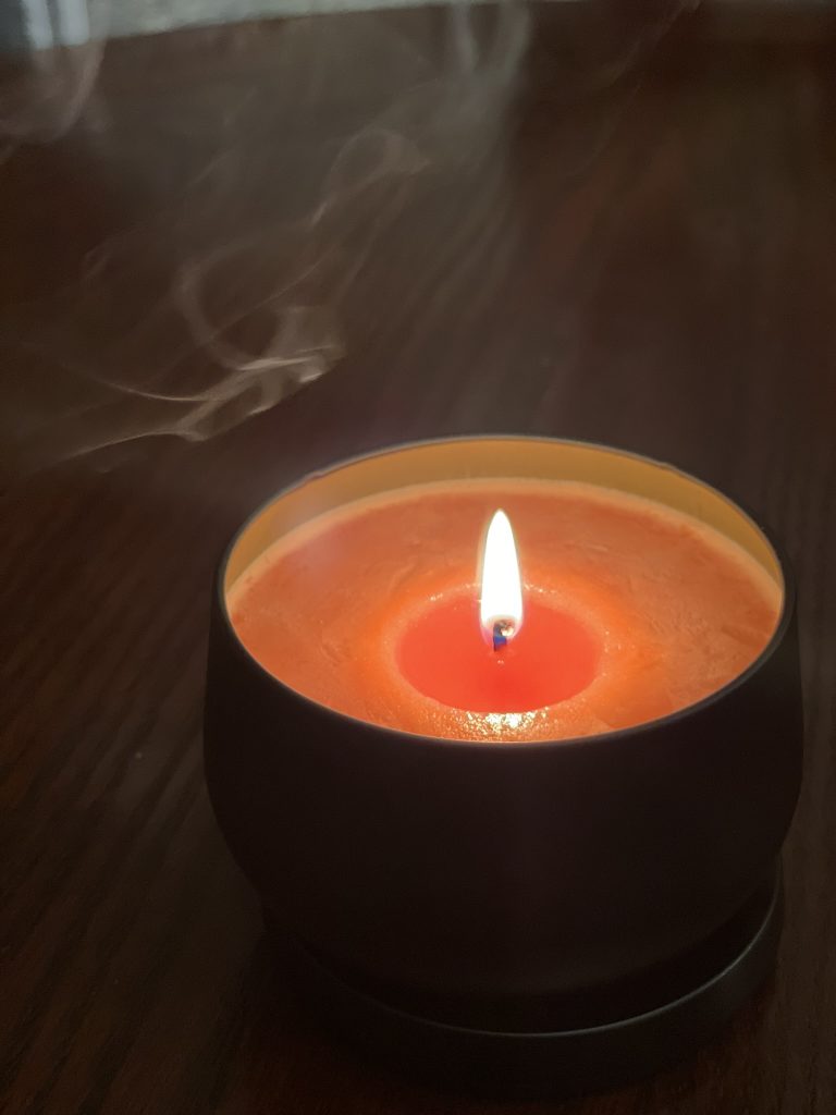 A single lit candle glowing in a darkened room